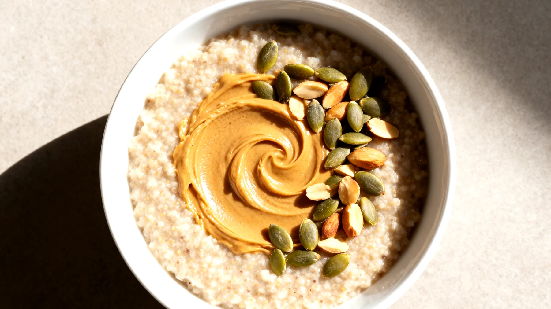 Amaranth-Porridge mit Mandelbutter und Kürbiskernen"