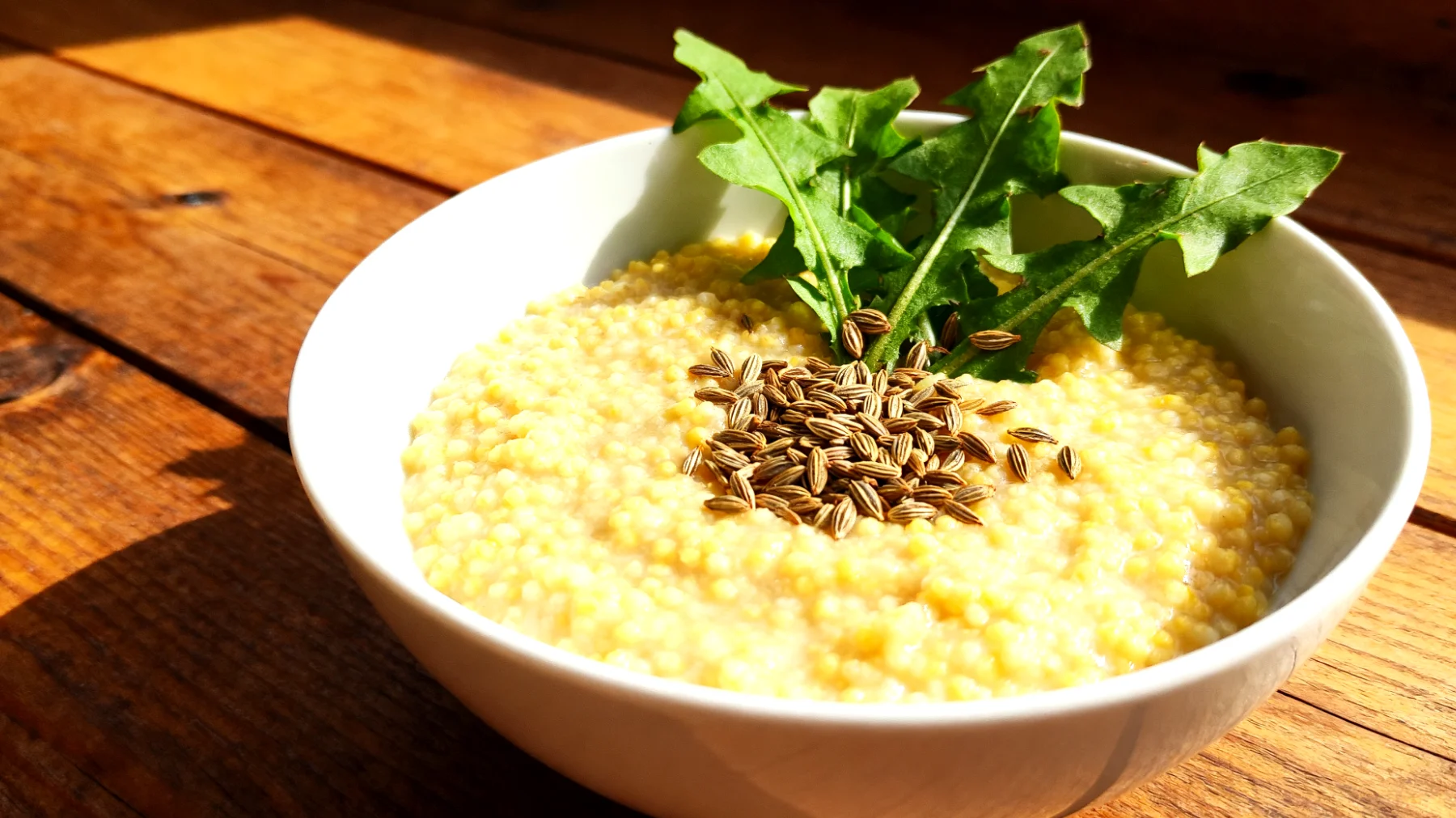 Hirsebrei mit Fenchelsamen und Löwenzahnblättern"